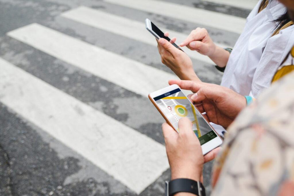 Person checks a mobile map app for directions while exploring a city, utilizing GPS for navigation.
