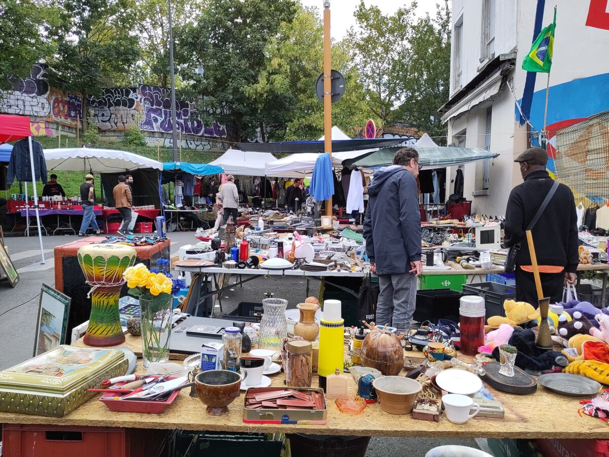 Marché aux Puces de Saint-Ouen in Paris, showcasing a vibrant flea market with tables overflowing with diverse items.