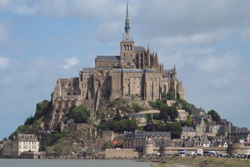 Mont Saint-Michel Abbey, a medieval castle on a Normandy island, captured in a panoramic view highlighting its grandeur.