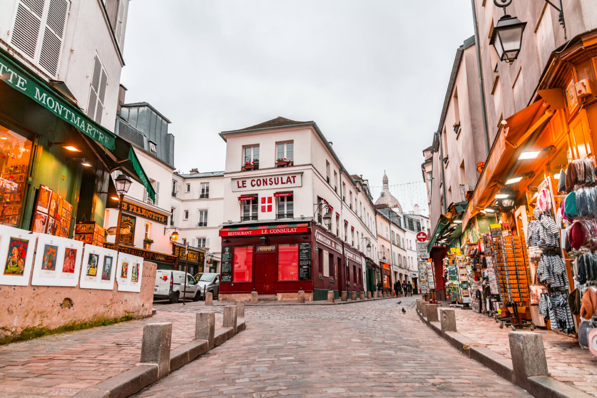 Picturesque street in Montmartre, Paris, featuring various shops and traditional buildings.