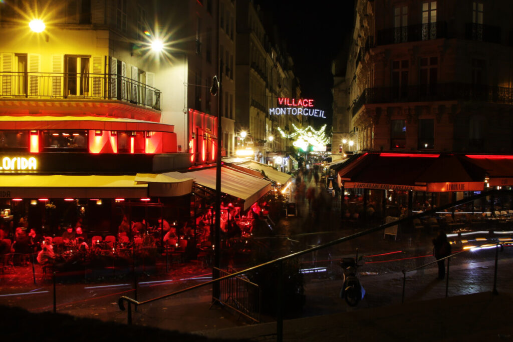 Restaurants at night and people having dinner in Montorgueil street, Paris, France