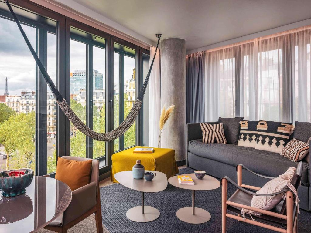 The lobby of Novotel Paris Porte Versailles exudes a welcoming ambiance with its stylish decor, comfortable seating, and natural light streaming through expansive windows