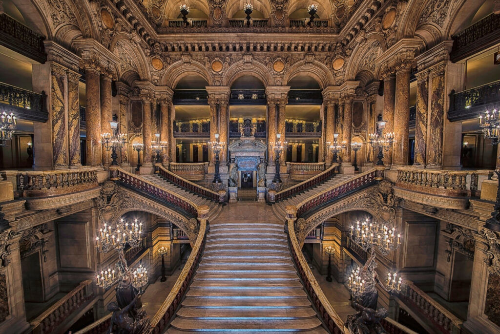 Grand stairway inside the Palais Garnier Opera House, showcasing ornate architecture and elegant design elements.