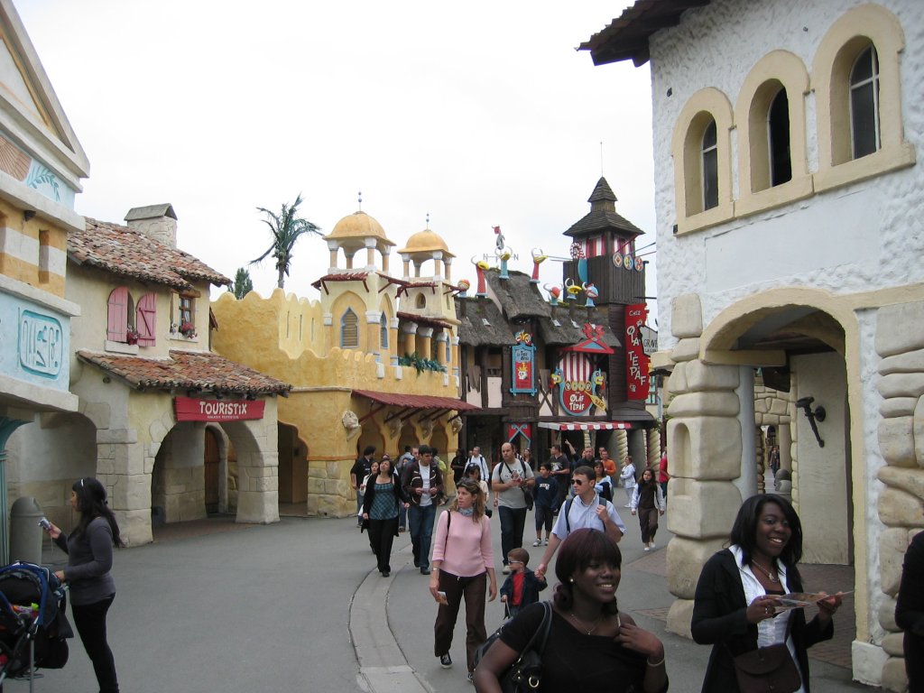 Visitors strolling along a street in Parc Asterix, Paris, France, surrounded by attractions and entertainment.