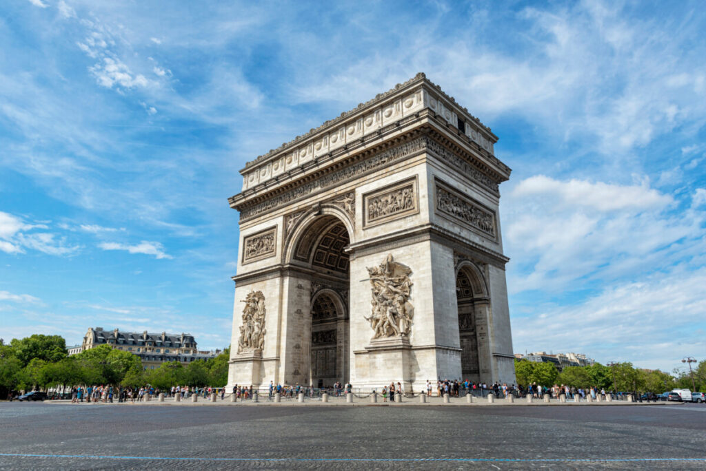 Tourists and architecture of Arc de Triomphe Monument in Paris, France