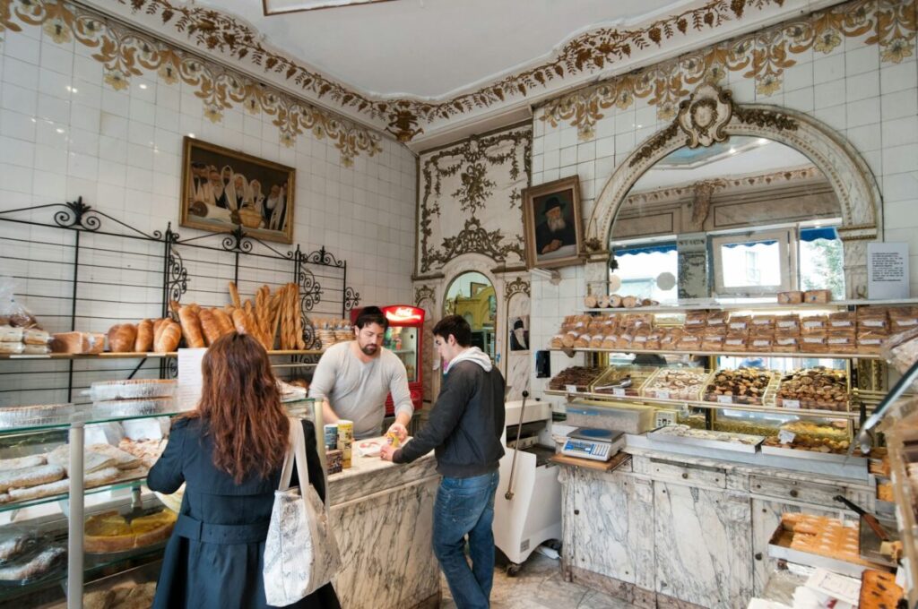 Locals buying bake goods on a bakery in Paris, France