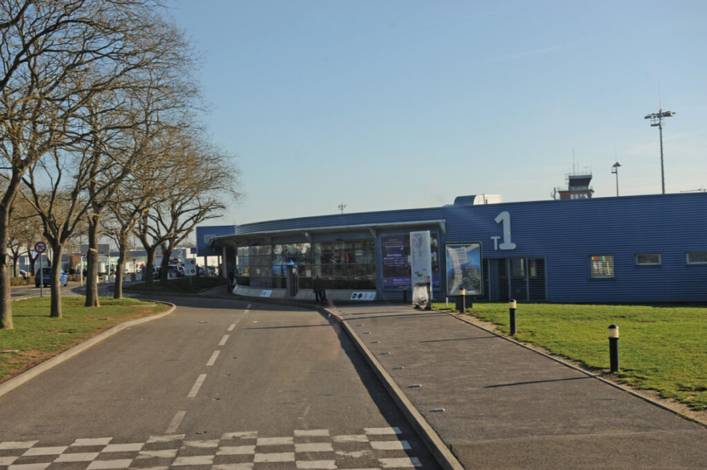 Blue building of Paris Beauvais Airport Terminal 1, showcasing modern architecture against a clear sky.