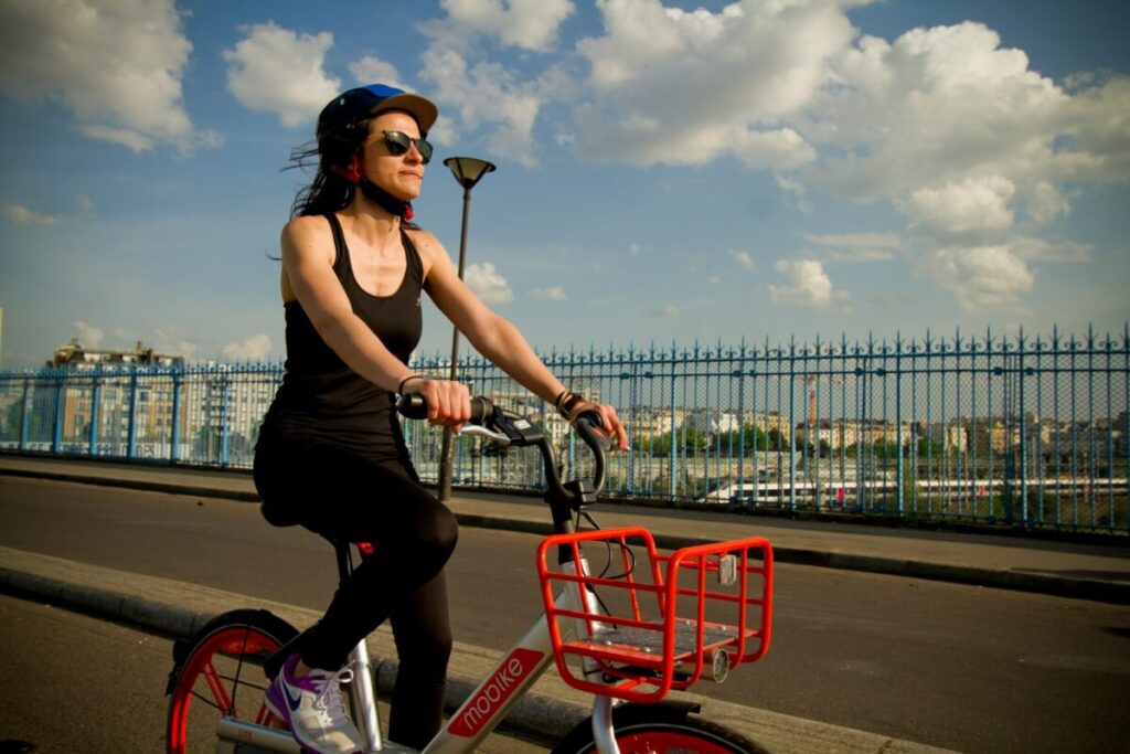 Woman riding a bike wearing a helmet in Paris, France