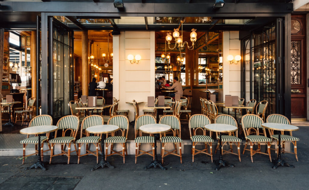 Parisian street scene featuring outdoor brasserie tables and chairs