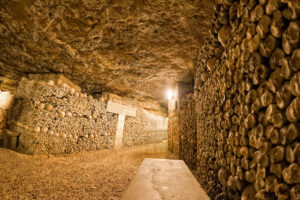 Rows of human skulls and bones in the Paris Catacombs, showcasing the eerie and historical burial practices of the city.