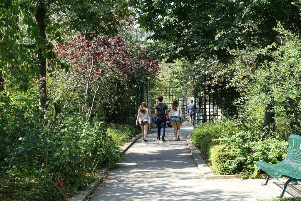 People strolling down the picturesque path of Coulée Verte René-Dumont in Paris, enjoying the lush surroundings.