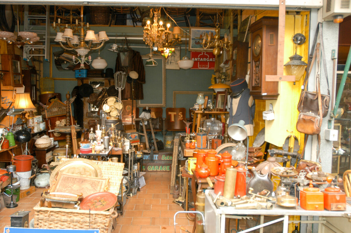 Clignancourt flea market in Paris, with numerous vendors and eclectic merchandise on display.