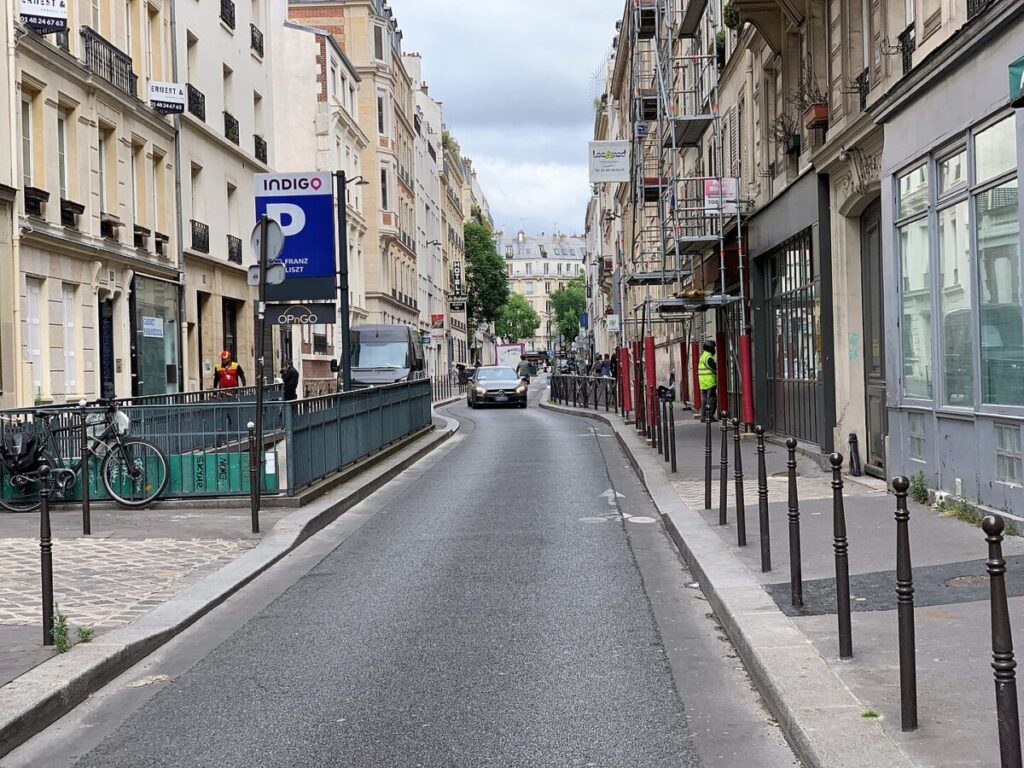 Street scene featuring a bike parked beside the road, with a Paris Indigo parking sign near Rue Petits Hôtels.