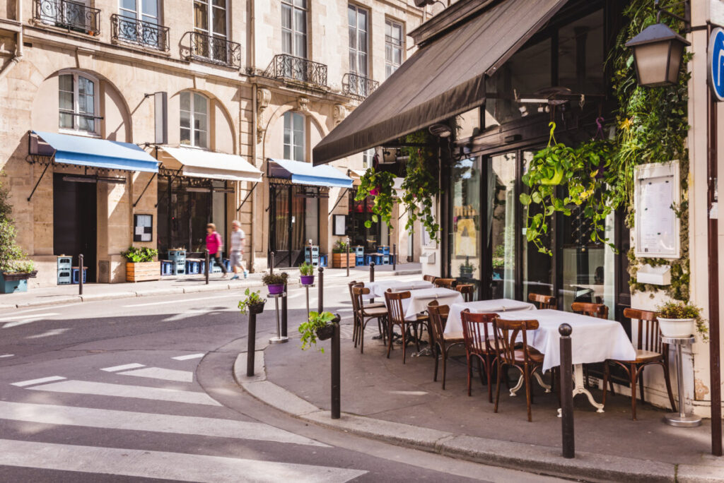 Charming Paris street lined with cozy restaurants and cafes, inviting patrons to enjoy outdoor dining and vibrant atmosphere.