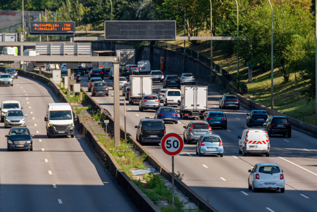 Traffic on the Paris Ring Road with a 50 km/h speed limit sign. The Périphérique is a road route around Paris, France