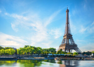 Sunrise over the Seine River in Paris, with the Eiffel Tower silhouetted against the colorful sky.