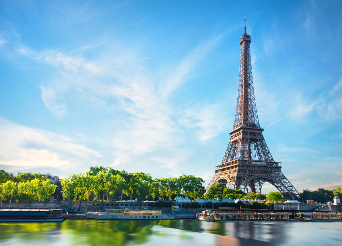 Sunrise over the Seine River in Paris, with the Eiffel Tower silhouetted against the colorful sky.