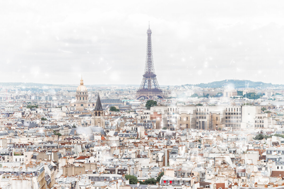 Aerial view of Paris rooftops in winter, featuring the Eiffel Tower against a clear sky.