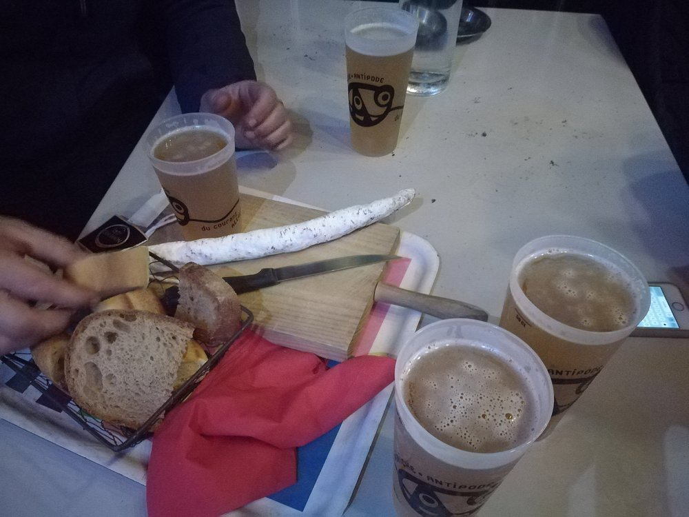 Tray featuring bread, a bottle of beer, and a glass of beer from Péniche Antipode Food.