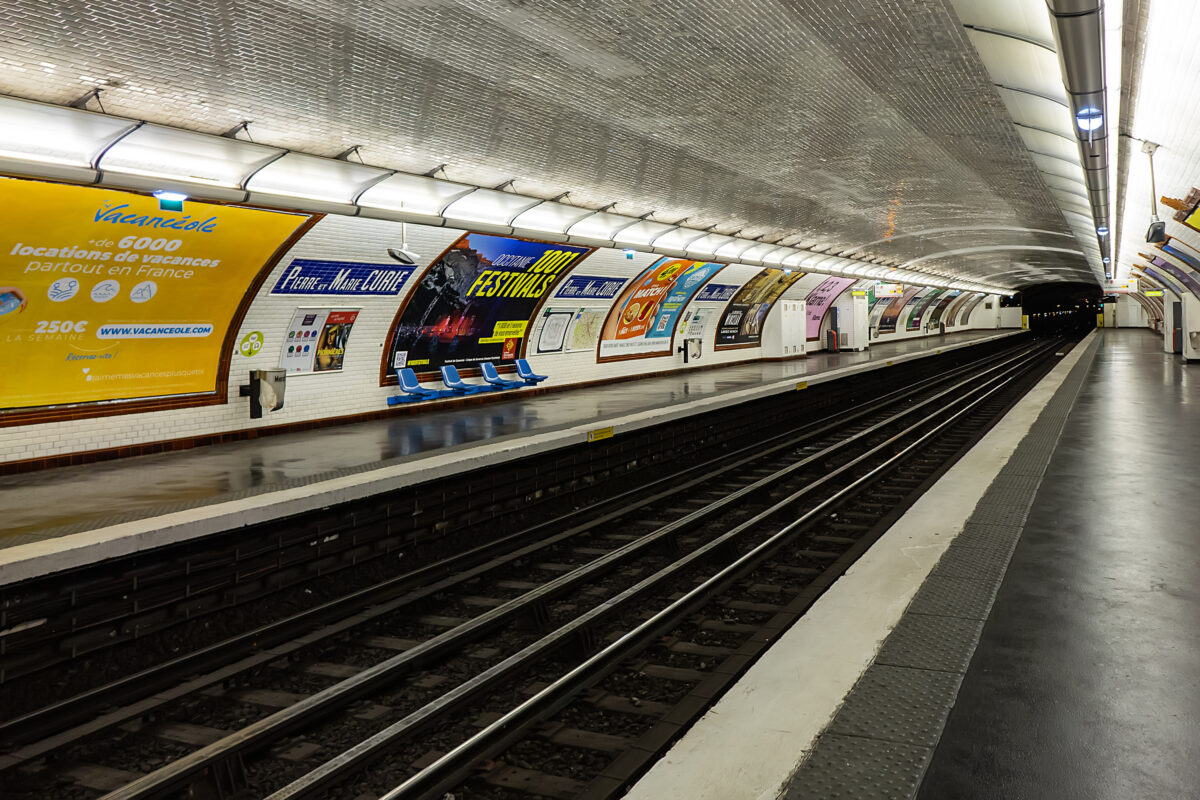 Inside Pierre et Marie Curie metro station, showcasing its architecture and layout on Line 7 of the Paris metro system.