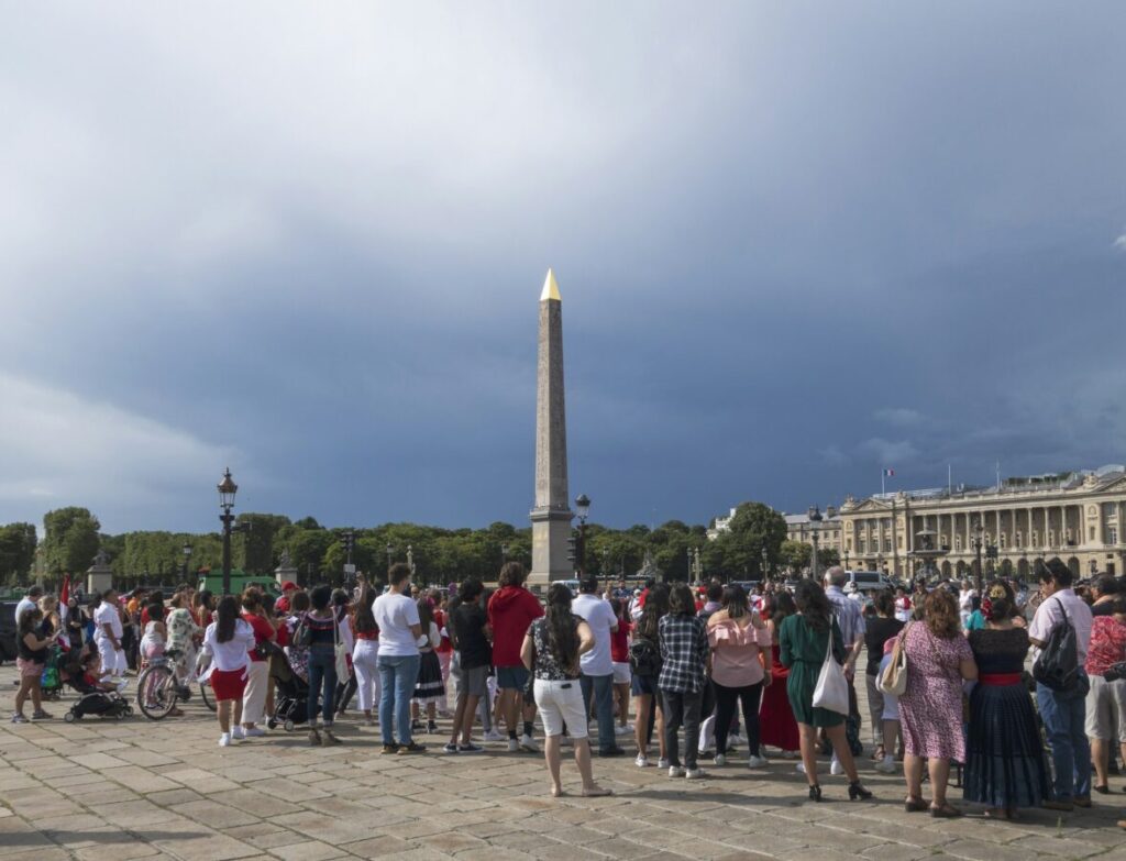 Tourists standing in front of a monument in Place de la Concorde, Paris, France