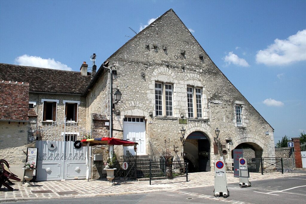 The front of a building with a prominent clock, situated at Place du Châtel, Provins.