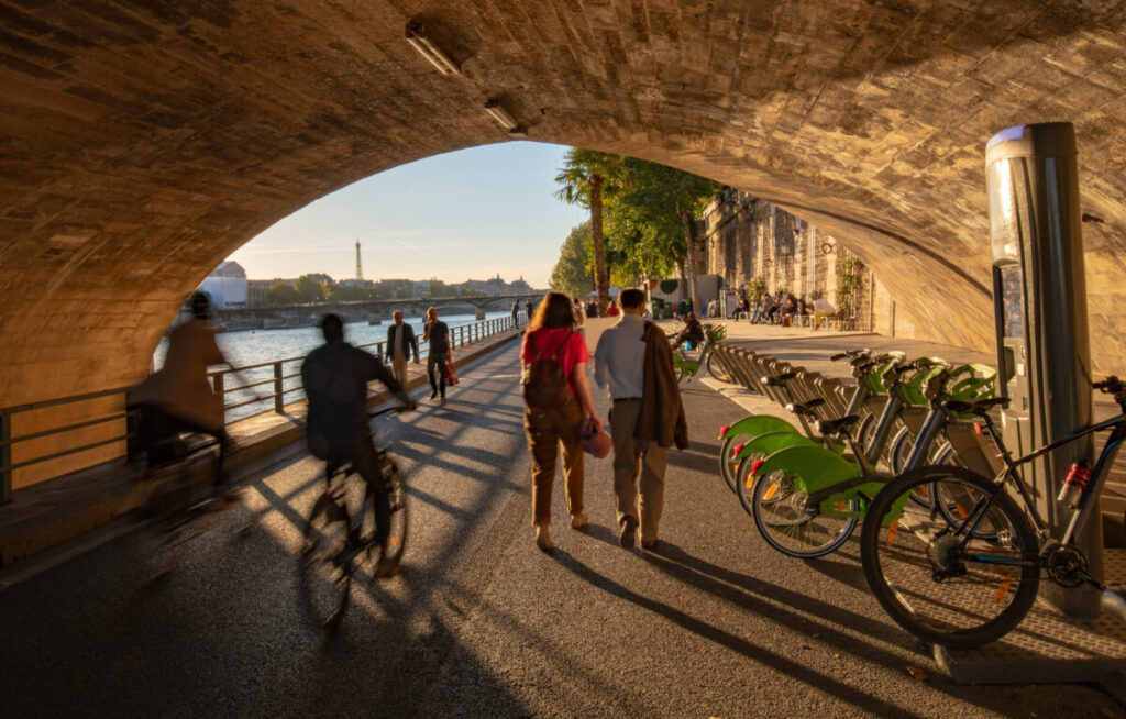 Bicycles available for rent beneath the Pont Neuf bridge along the Seine riverbank.