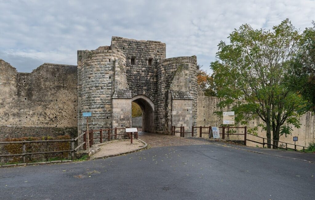 The historic Porte Saint-Jean in Provins, France, featuring a large stone structure with a prominent gate and sign.