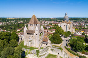 Scenic view of Provins, France, showcasing medieval architecture and lush greenery under a clear blue sky.