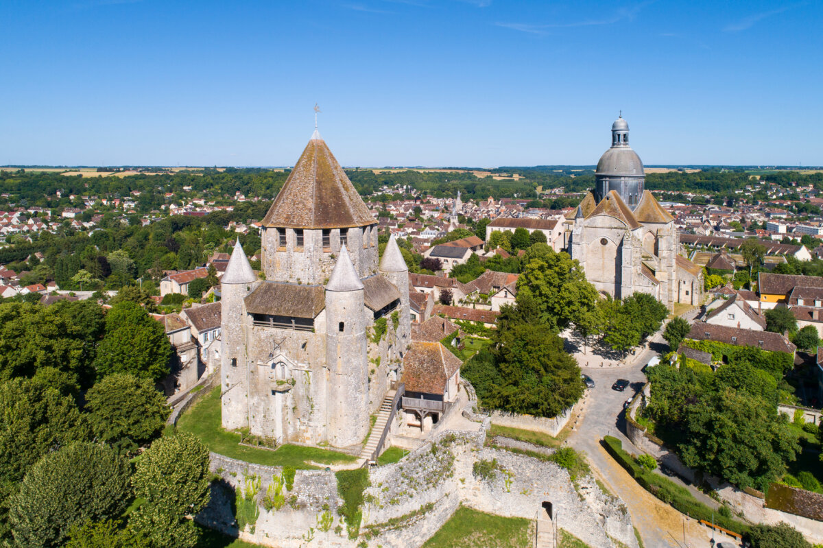 Scenic view of Provins, France, showcasing medieval architecture and lush greenery under a clear blue sky.