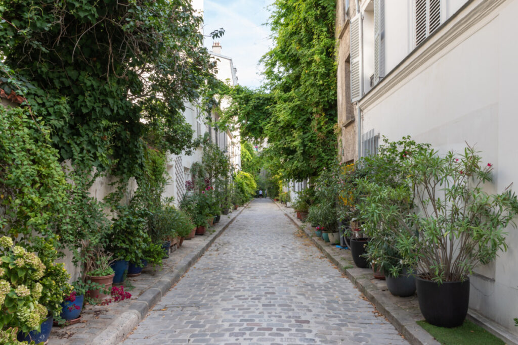 Charming Rue des Thermopyles street with lots of plants in Paris, France