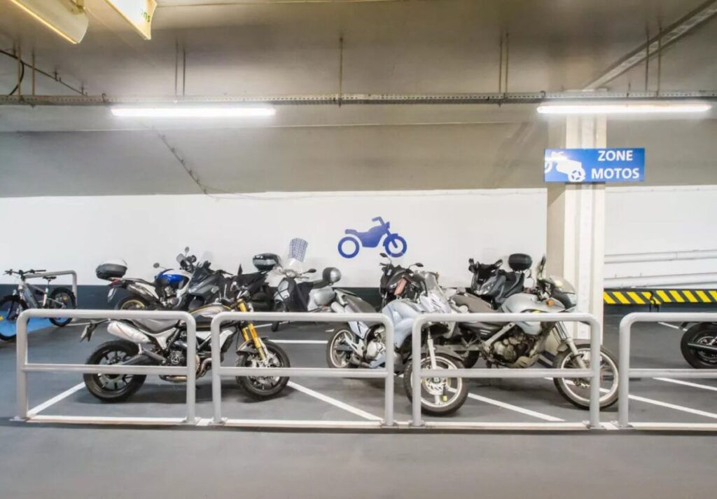 Motorcycles parked in the Saeme Parking Space at Porte Dorléans, showcasing a variety of models in a garage setting.