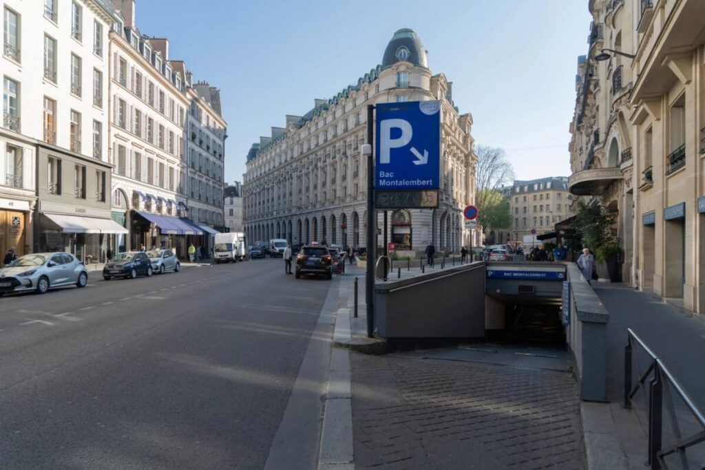 Street lined with parked cars on both sides, featuring signage for Saemes Paris Parking.