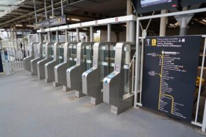 Ticket barriers with a map displayed at the Saint-Michel Notre-Dame train station in Paris, France.