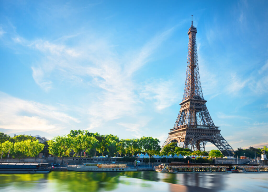 The Eiffel Tower stands tall over the Seine River in Paris, France, showcasing its iconic iron lattice structure.