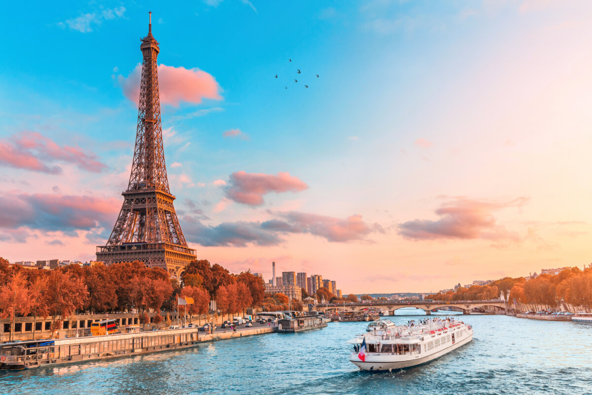 Scenic sunset over the Seine River during a tranquil cruise, with silhouettes of Parisian landmarks in the background.