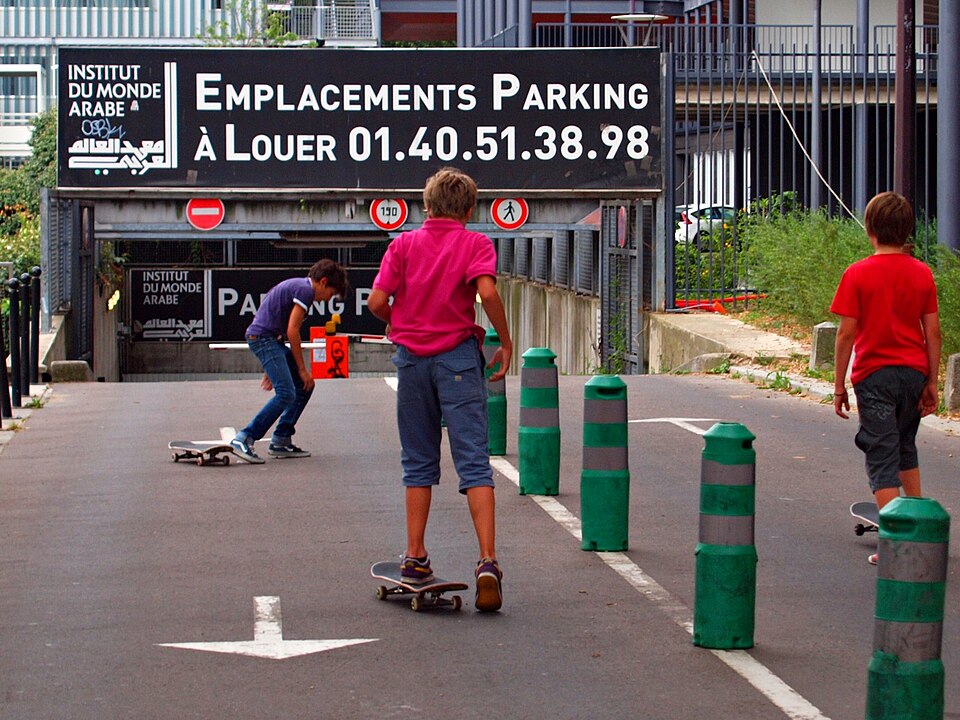 Tow teens skateboarding on a street in Paris