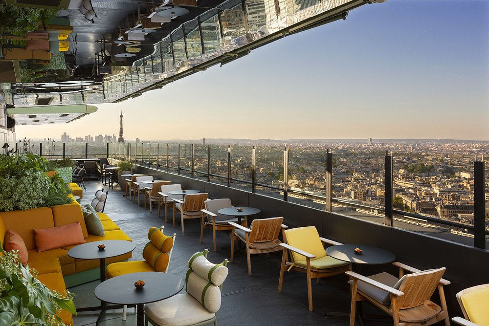 Rooftop restaurant Skybar Paris with tables and chairs, offering a panoramic view of the city skyline.