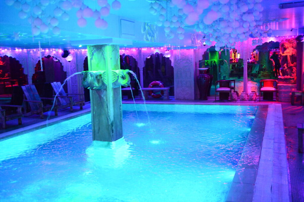 Serene pool featuring purple lights and festive balloons, found within the sauna area of Sun City in Paris, France.