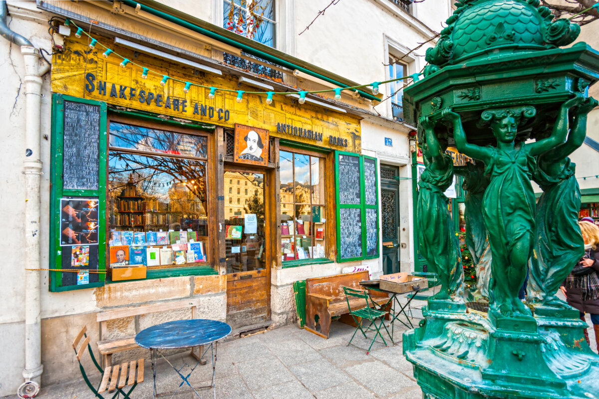 The exterior of Shakespeare and Co. bookstore in Paris, featuring its iconic green facade and inviting entrance.