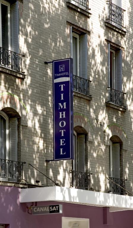 Exterior view of Timhotel Boulogne Rives de Seine showcasing modern architectural design with a blend of glass and steel, set against a backdrop of the Seine River.