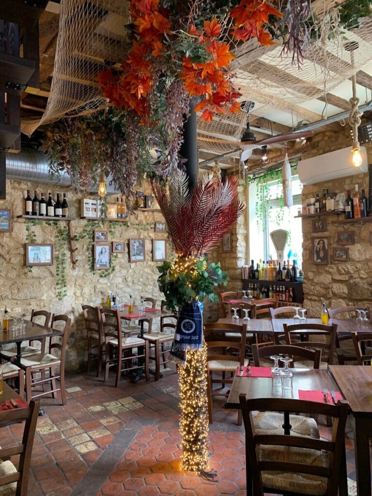 Cozy interior of Trattoria du Val Provins, France, featuring tables and chairs arranged for dining.
