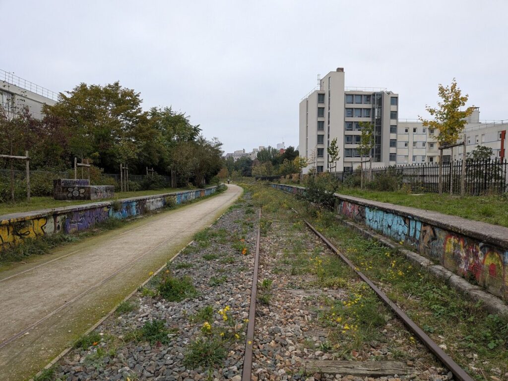 Train track in Vincennes Railway, Paris, featuring colorful graffiti along the rails.