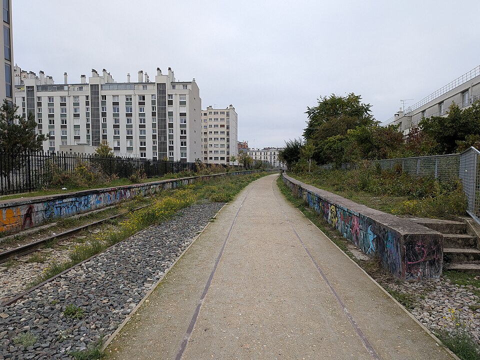 Empty path with graffiti along the sides, located at Vincennes Railway in Paris, France.
