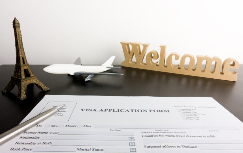 Visa application form on a table with a place an Eiffel tower figurines