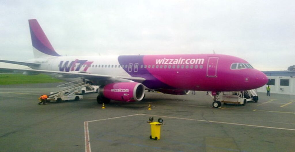 WizzAir Beauvais Airport features a pink and purple airplane parked on the tarmac.