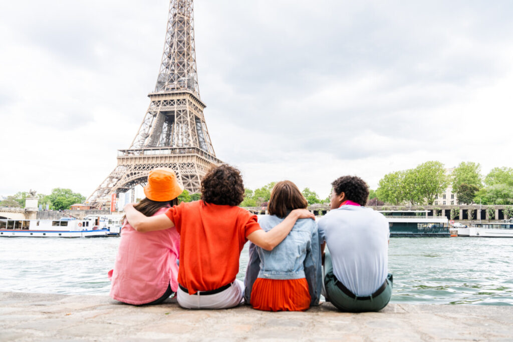 Group of young travelers looking at the Eiffel Tower in Paris, France